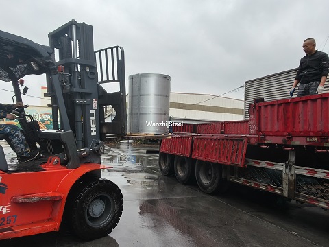 Packaged PPGI steel coils loaded onto trucks for transportation