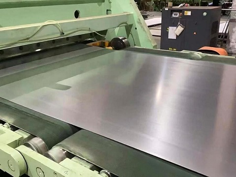 Operator cutting marine grade stainless steel sheet to length on the processing line