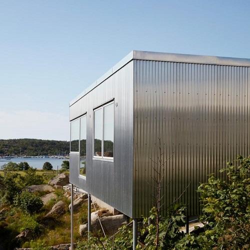Coastal building facade clad with marine grade stainless steel sheet panels